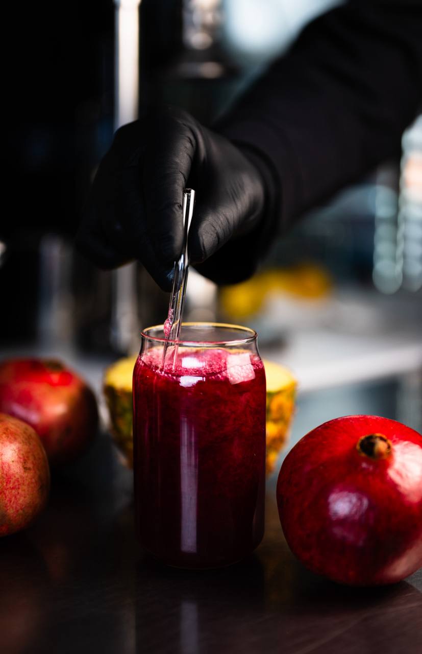 Pomegranate juice being stirred with pineapple and fruit